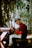 a man sitting on a bench playing a guitar
