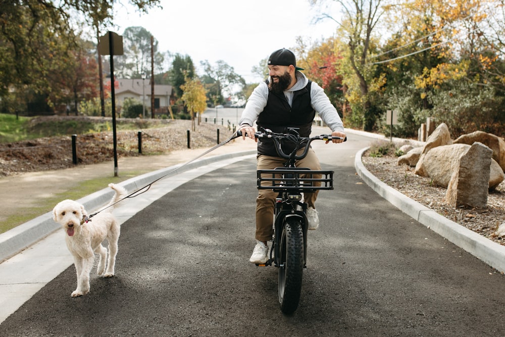 a man riding a bike with a dog on a leash