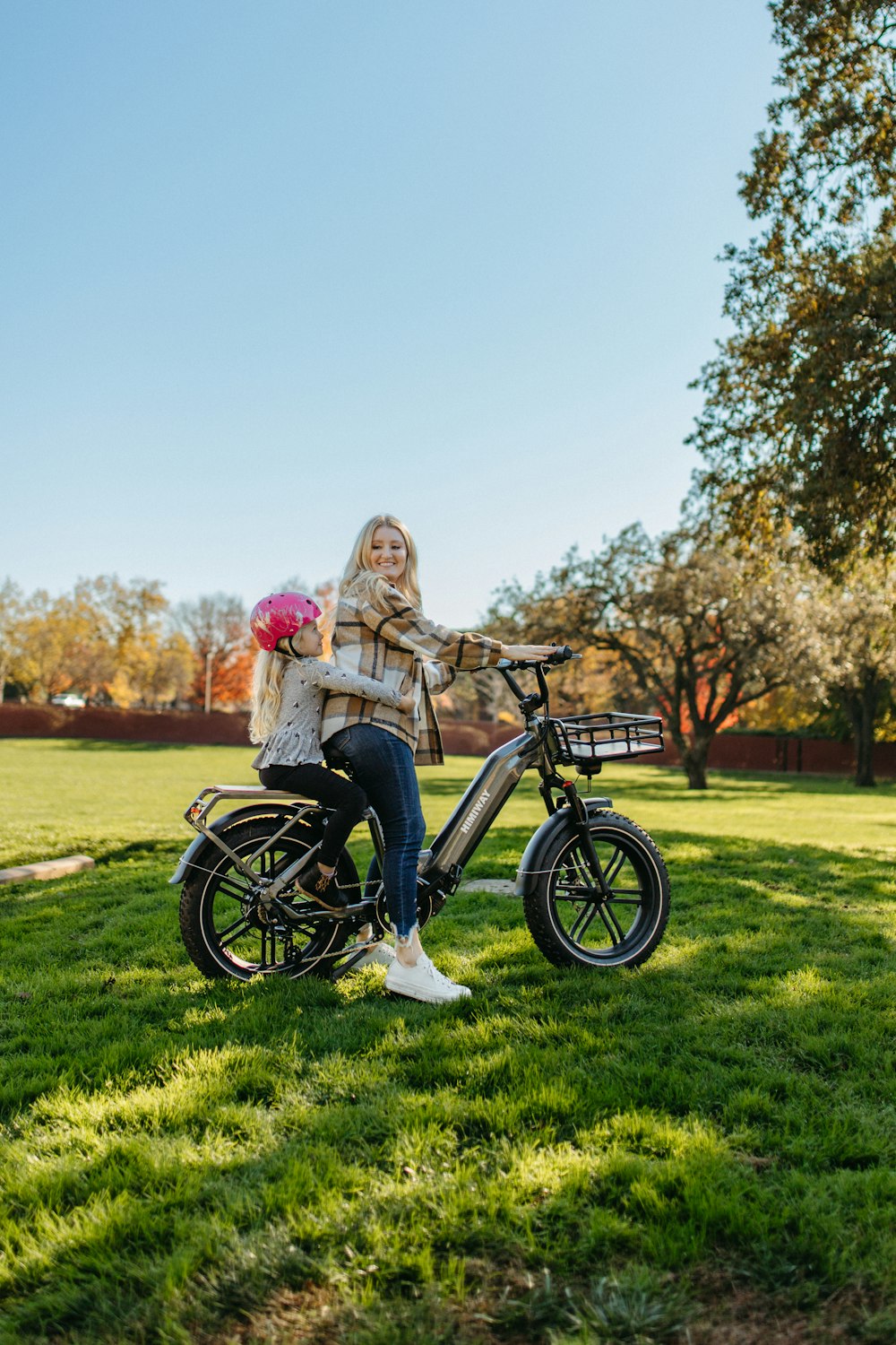 a woman sitting on a bike in the grass