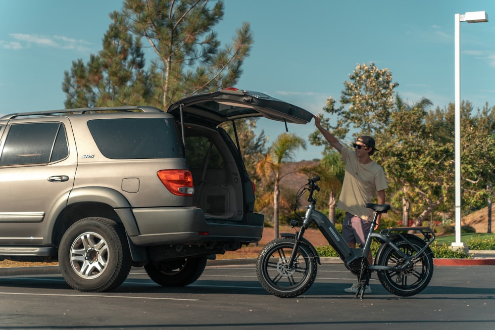 a man standing next to a car with a bike in front of it