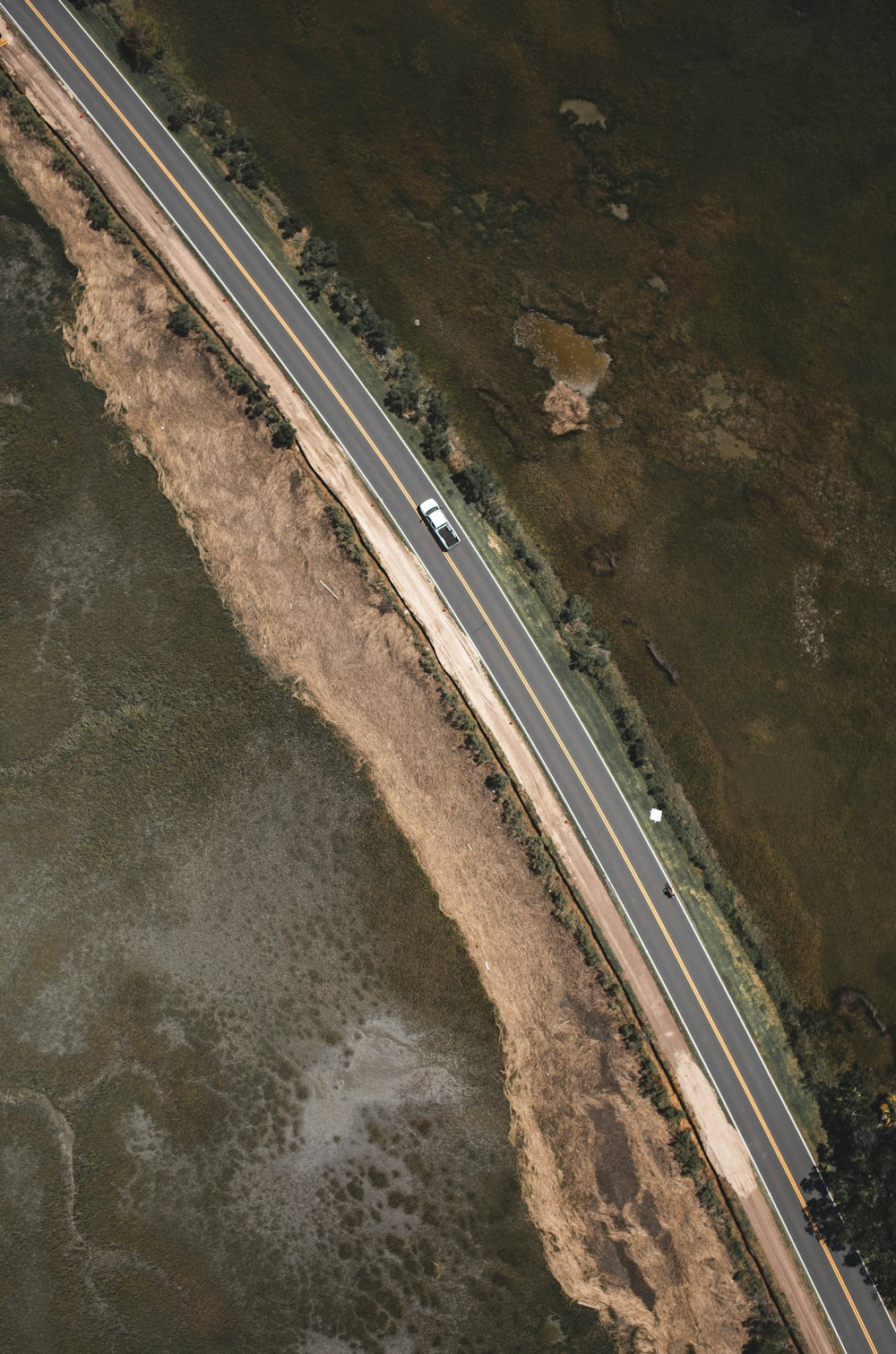 an aerial view of a highway and a body of water