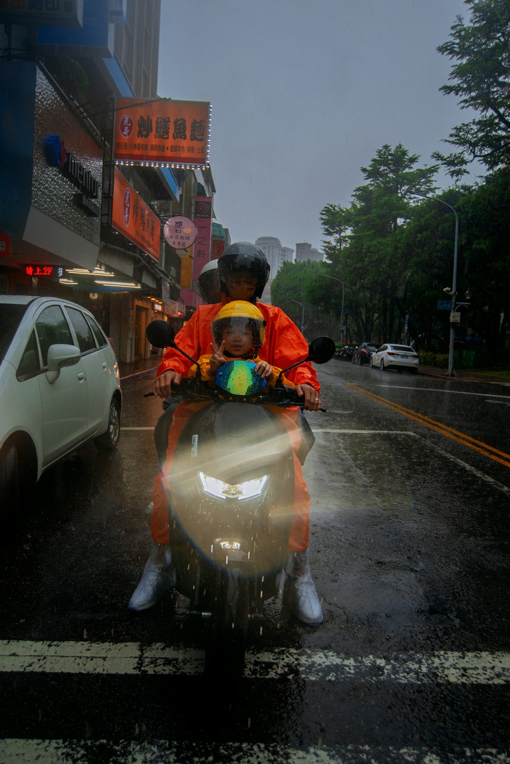 a man riding a motorcycle down a rain soaked street