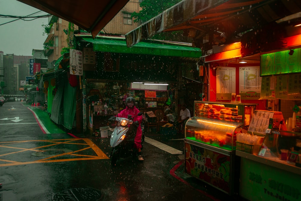 a person riding a motorcycle down a wet street