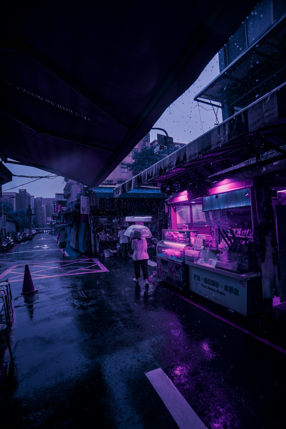 Eine Person mit einem Regenschirm geht die Straße entlang