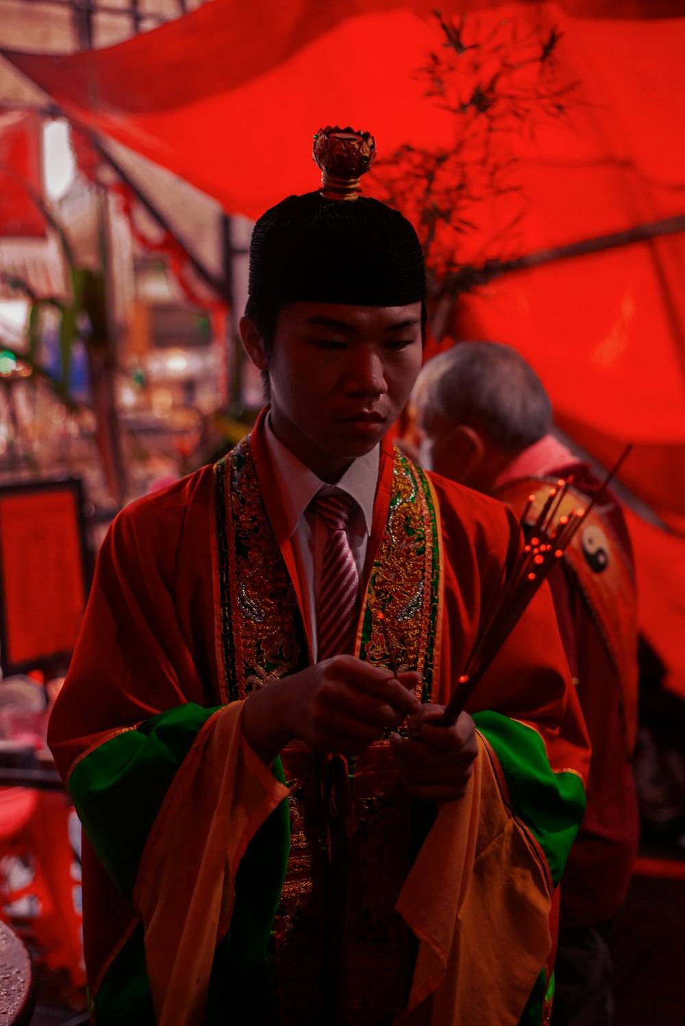 a man in a red and green outfit looking at his cell phone