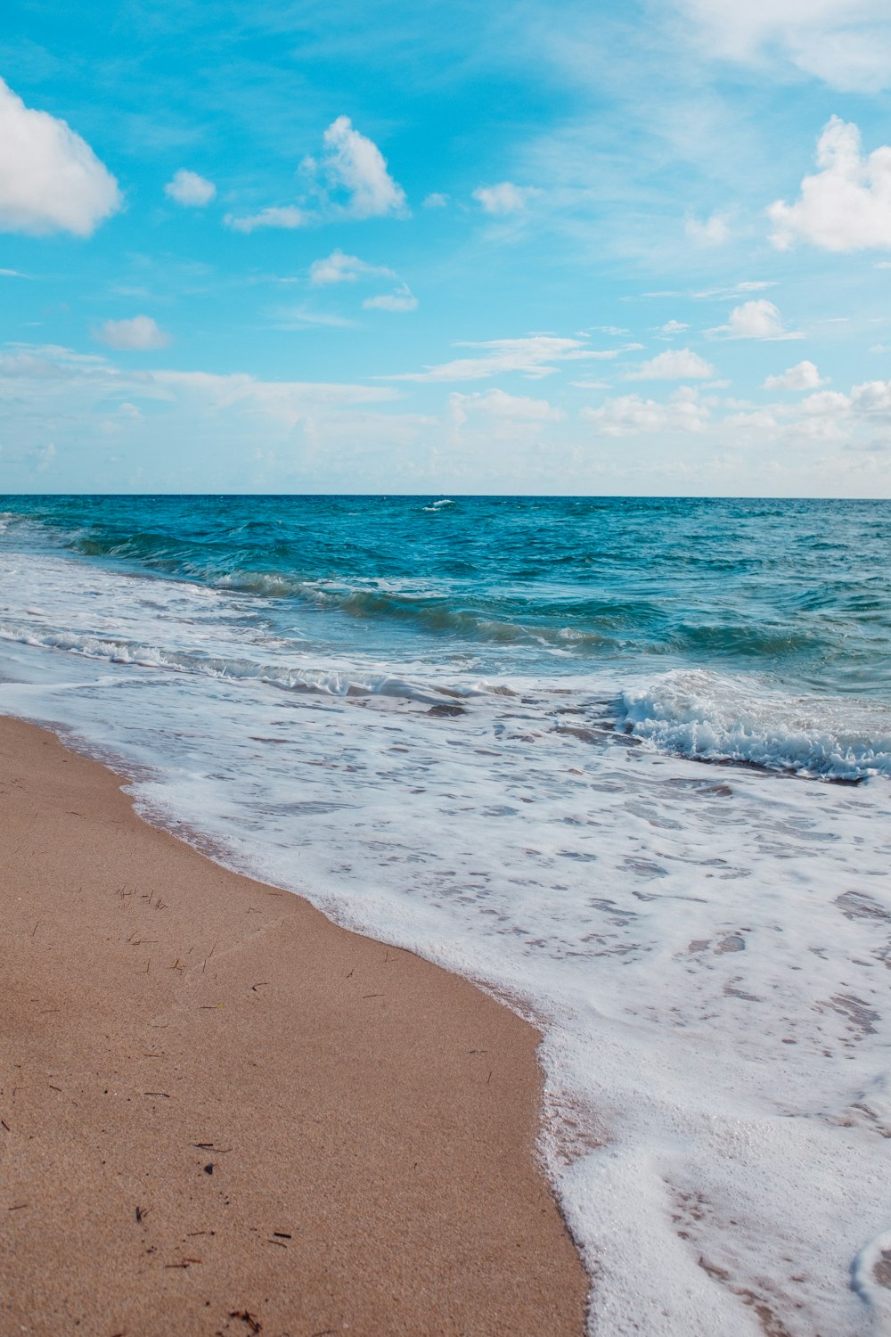 a sandy beach with waves coming in to shore