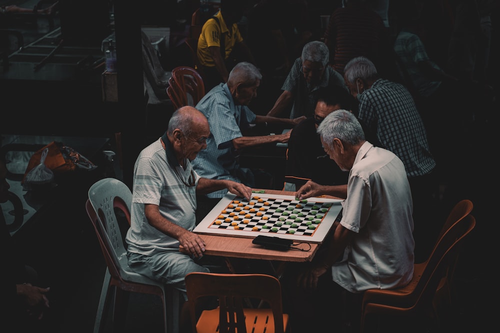 a group of older men playing a game of chess