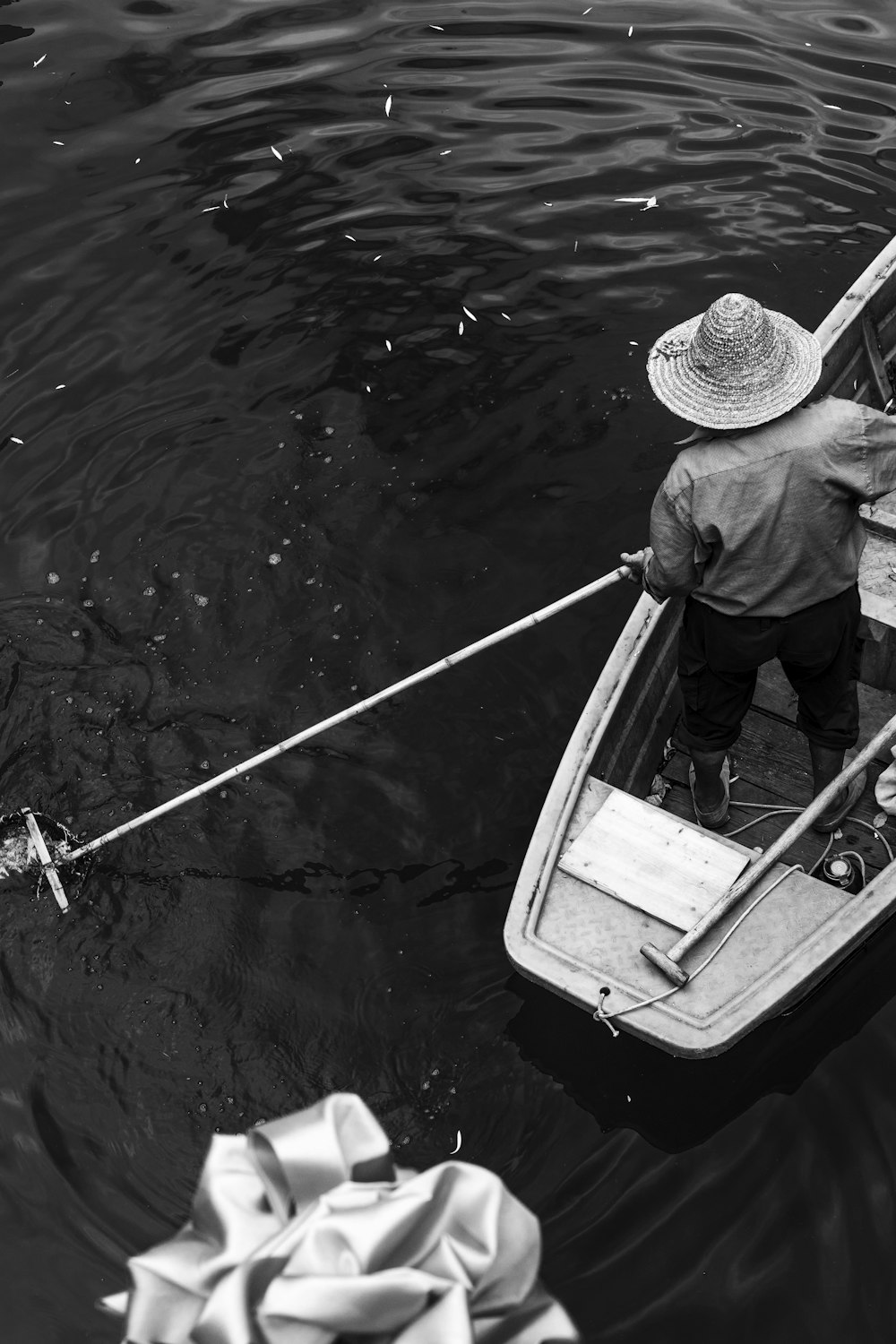 a black and white photo of a man in a boat