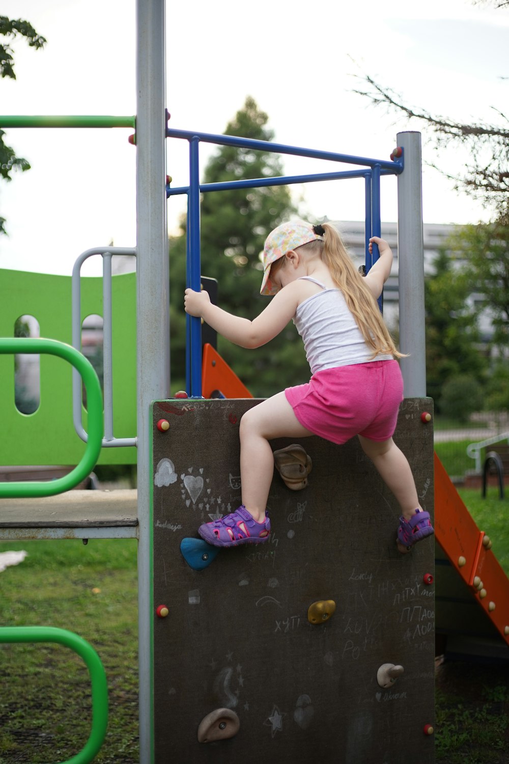 a little girl climbing on a climbing wall