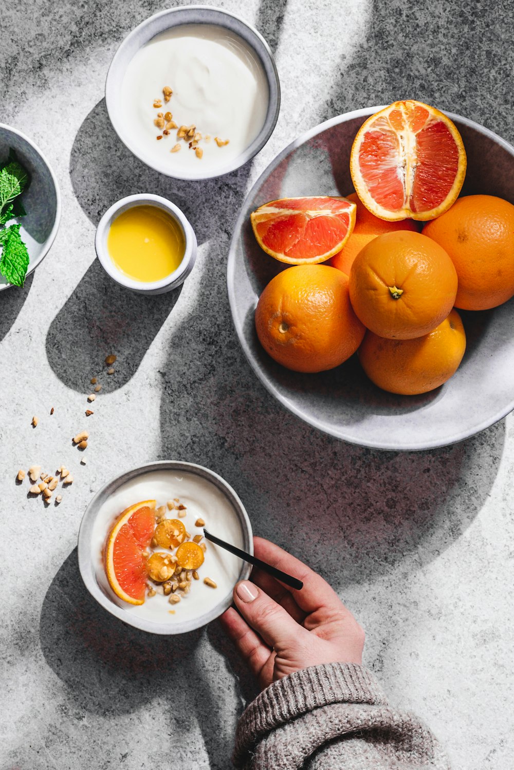 a person holding a bowl of oranges and yogurt