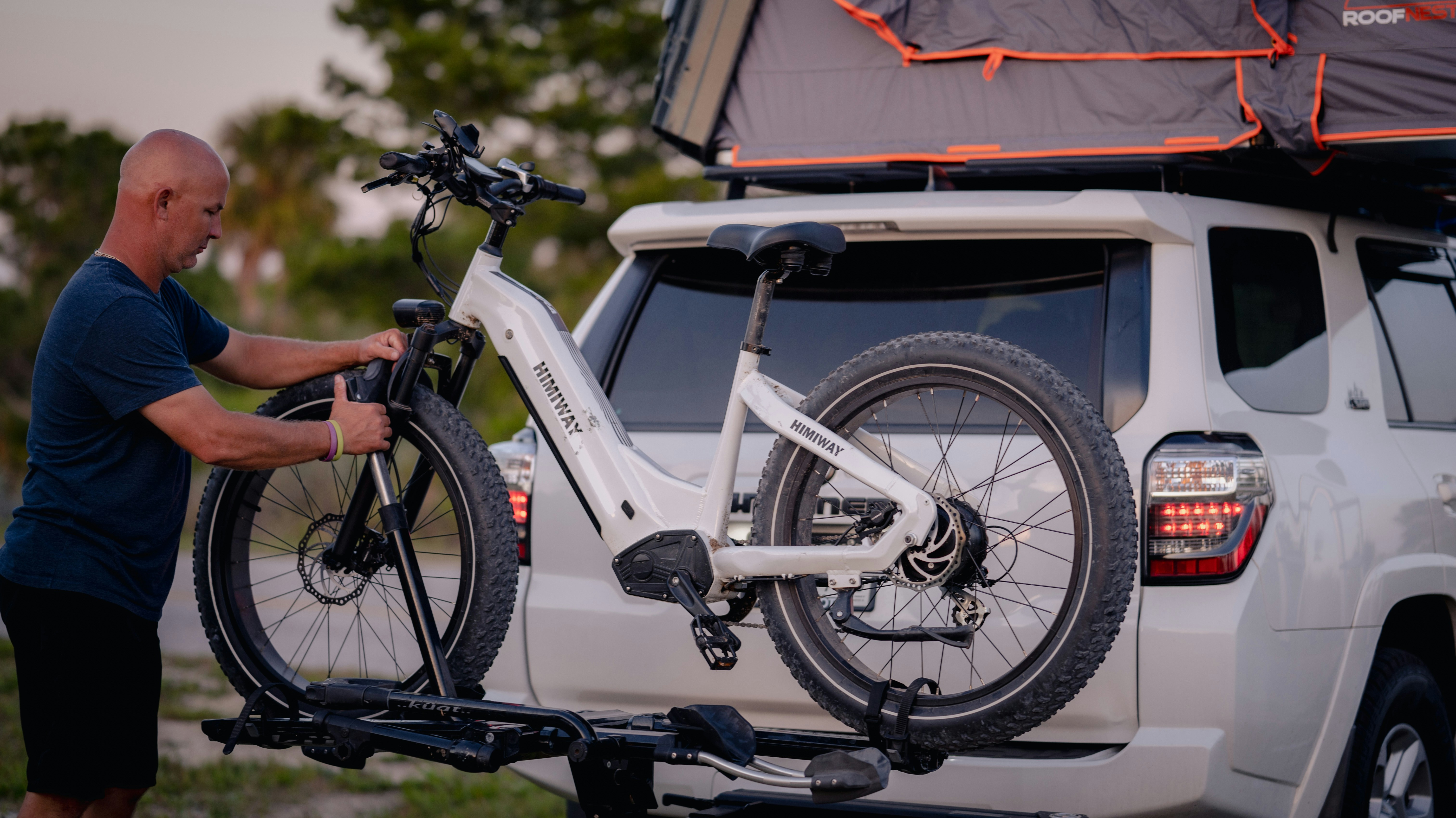 a man putting a bike on the back of a truck
