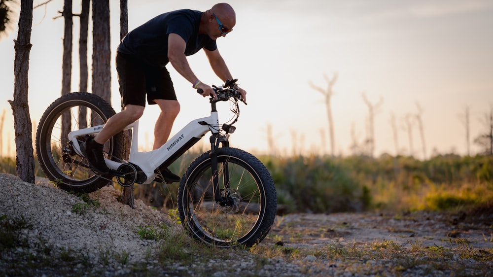 a man riding a bike down a dirt road