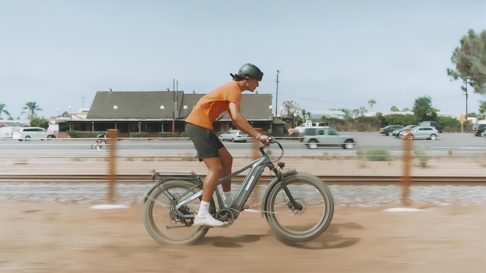 a man riding a bike down a dirt road