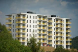 a tall white building with yellow balconies