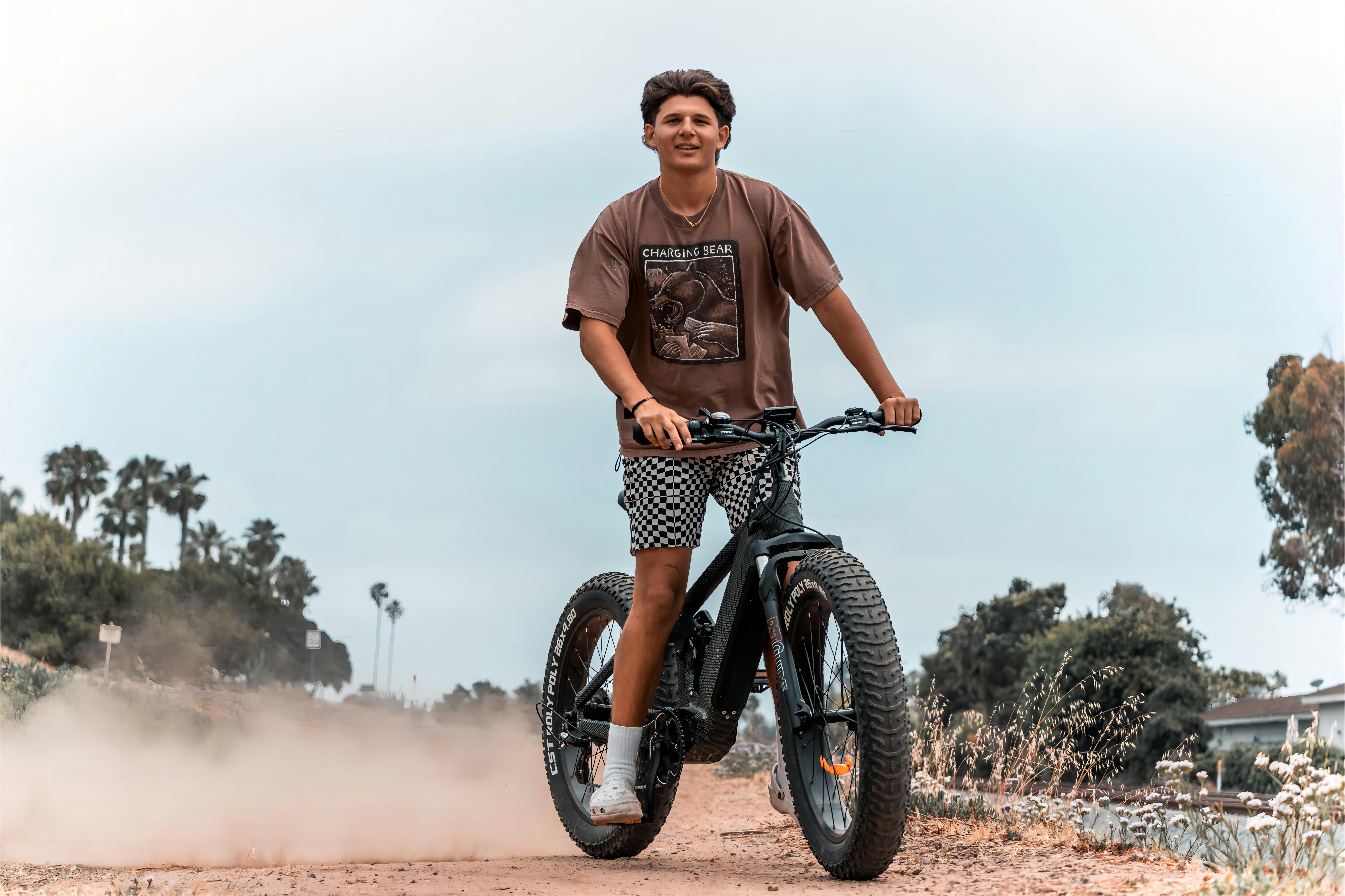 a man riding a bike down a dirt road