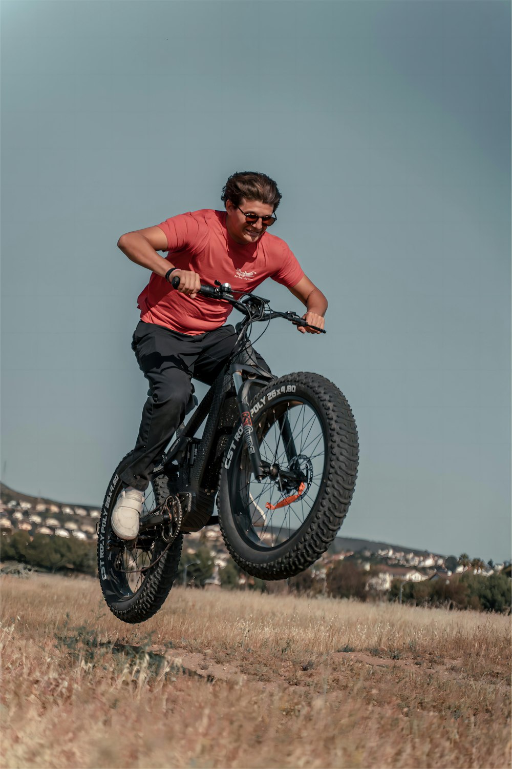 a man riding a dirt bike through a dry grass field