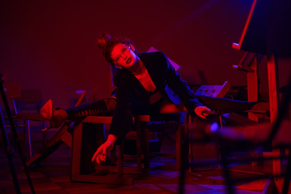 a woman sitting on a chair in a dark room