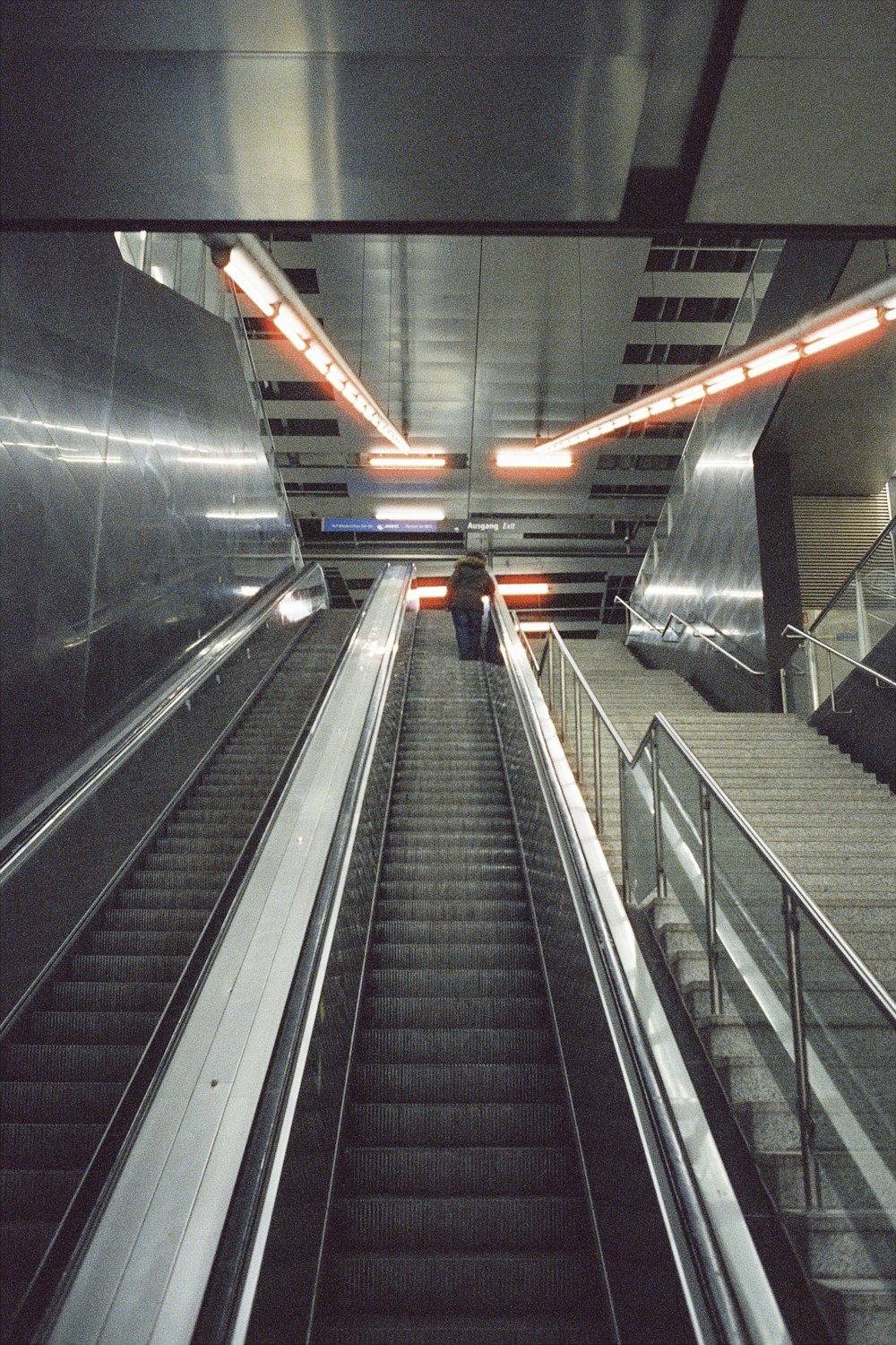 an escalator in a subway station with a person walking down it