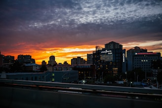 A stunning view of a luxury hotel overlooking a vibrant city skyline at sunset.