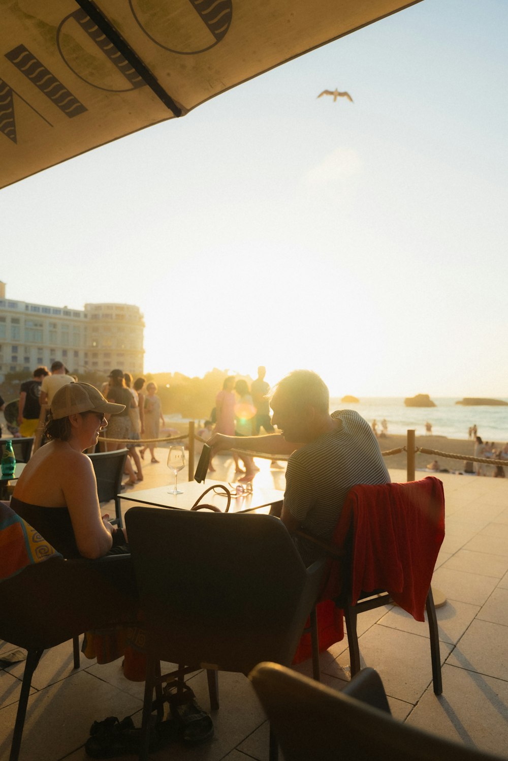 a group of people sitting at a table on the beach