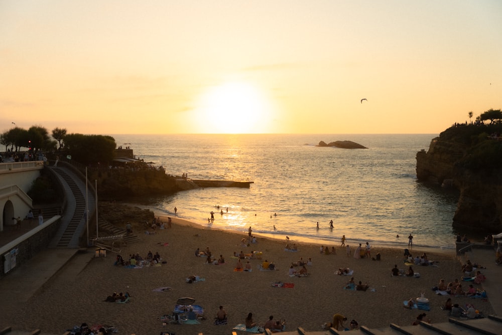 a group of people sitting on top of a sandy beach