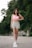 a woman in a pink top is walking down the street
