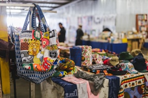 A close-up of a tote bag adorned with colorful West African motifs and intricate beadwork.