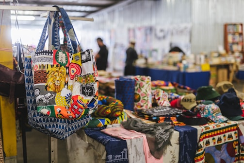 A close-up of a tote bag adorned with colorful West African motifs and intricate beadwork.