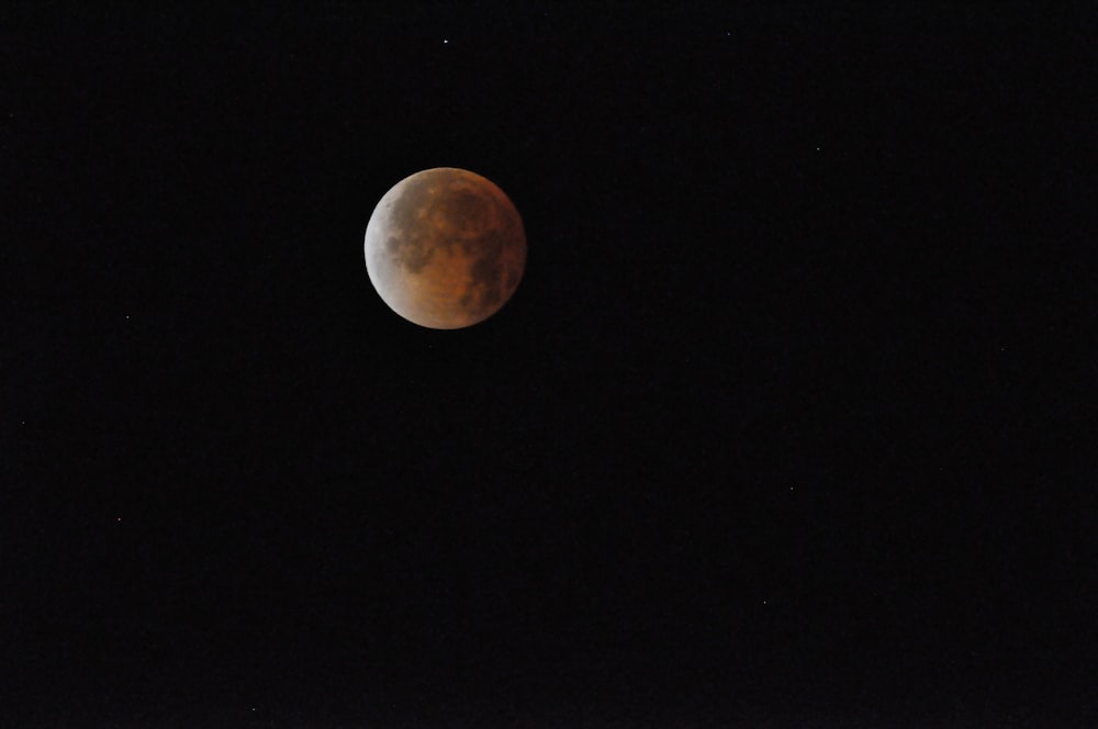 Une lune rouge est vue dans le ciel sombre