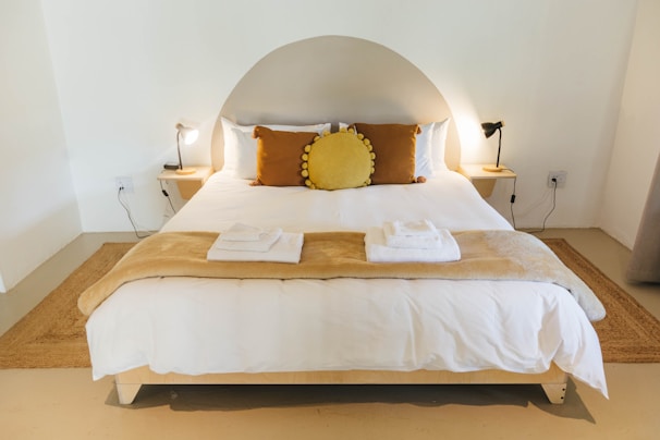 A neatly made bed with a soft duvet cover and matching pillowcases in a minimalist room.