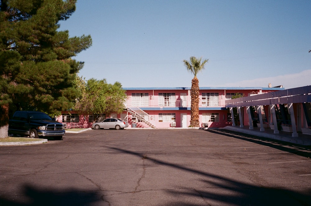 a parking lot with cars parked in front of a motel