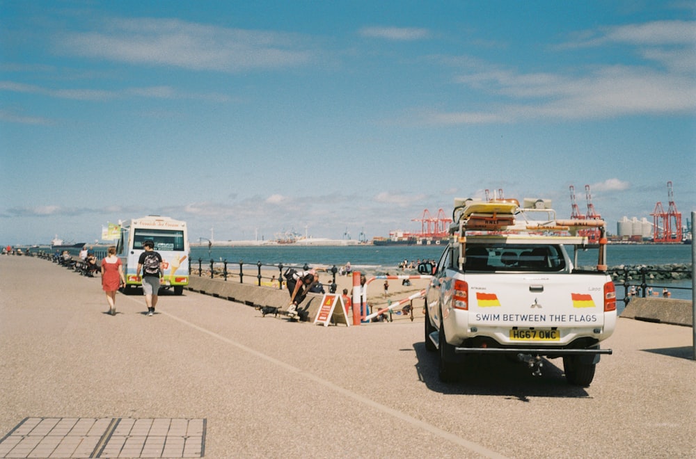 a white van parked on the side of a road next to a body of water