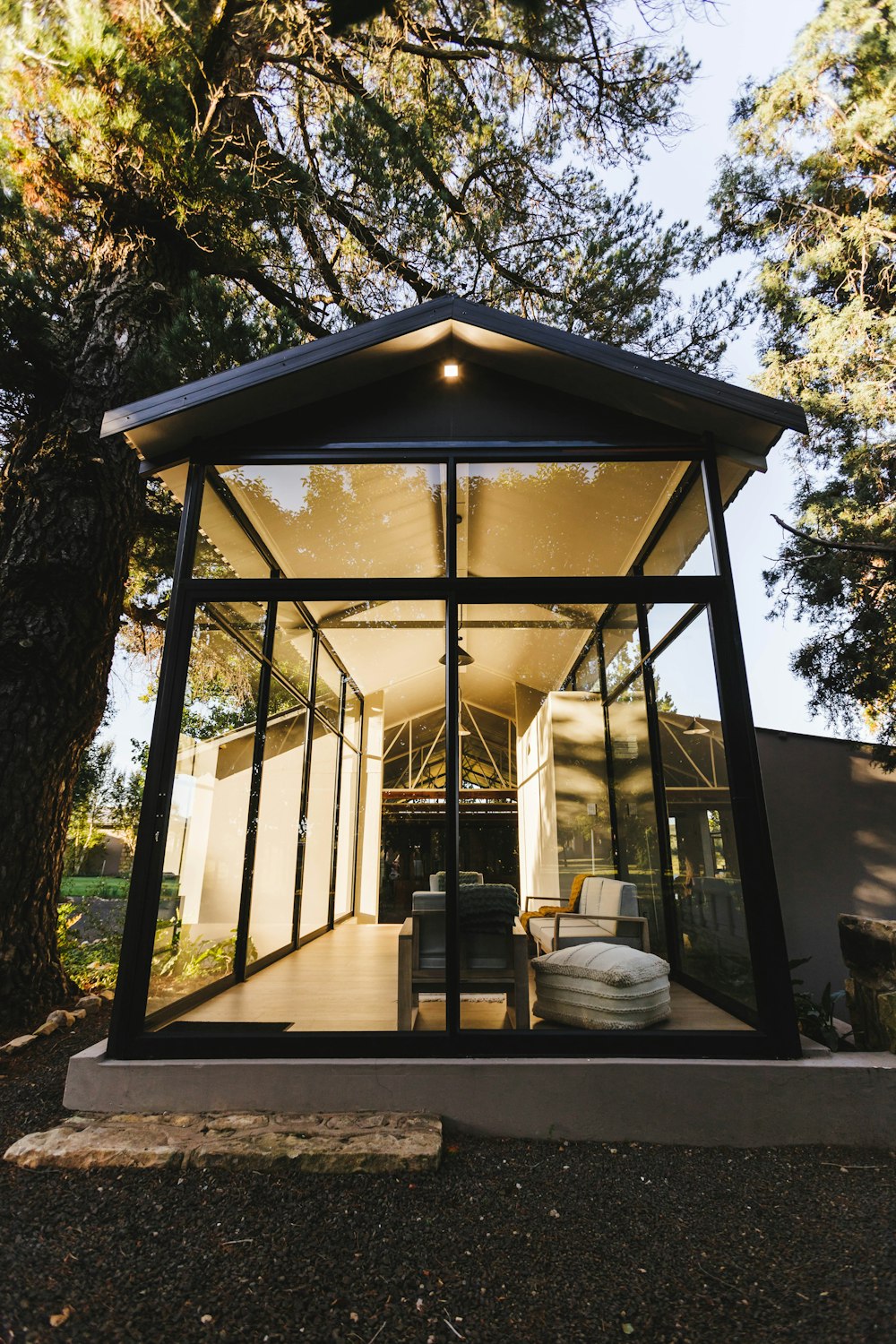 a glass house in the middle of a forest
