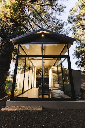 a glass house in the middle of a forest