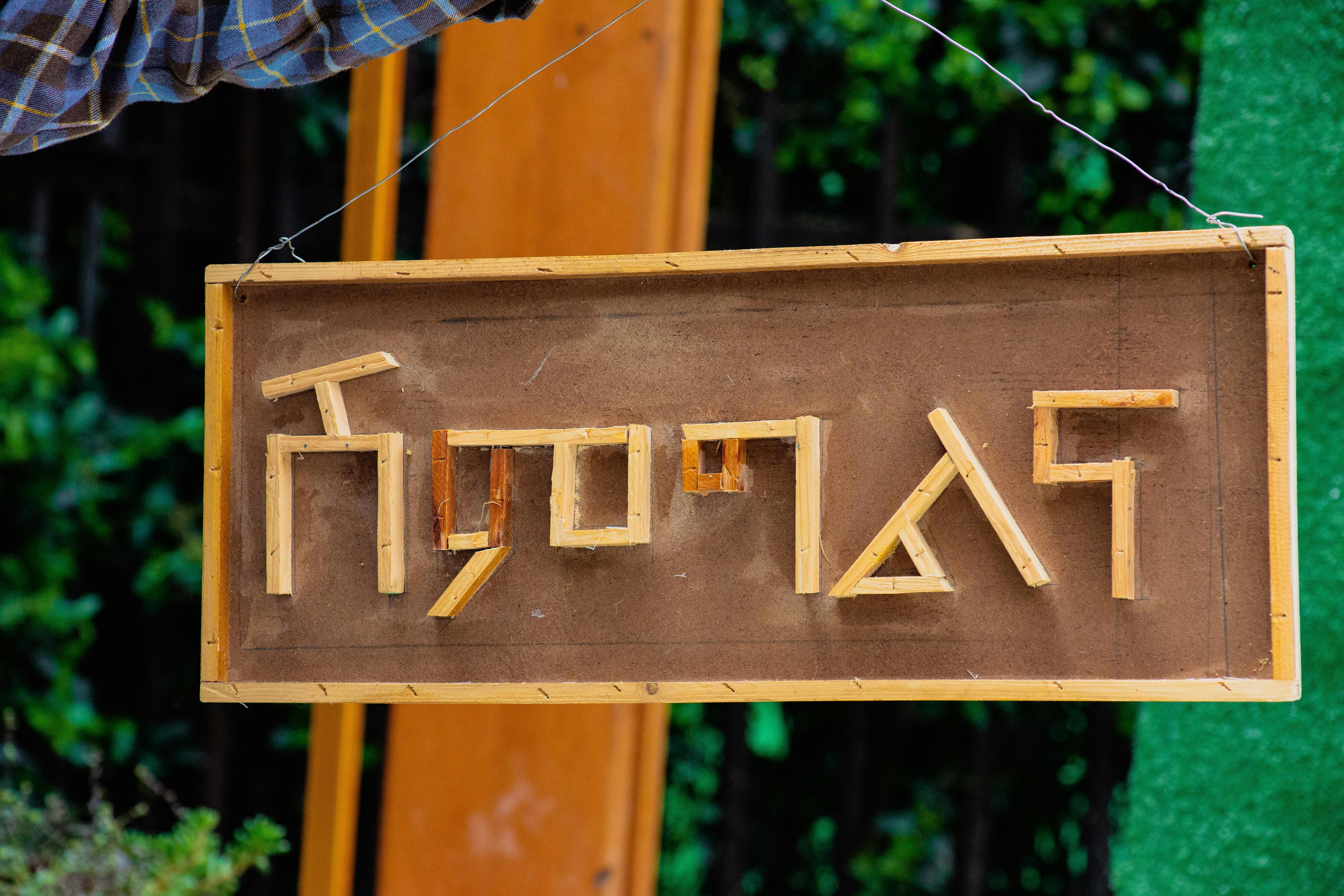 a wooden sign hanging from the side of a building