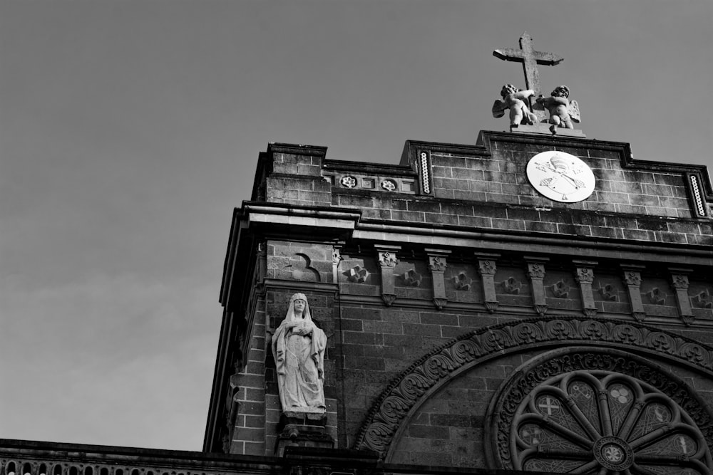 a black and white photo of a statue on top of a building