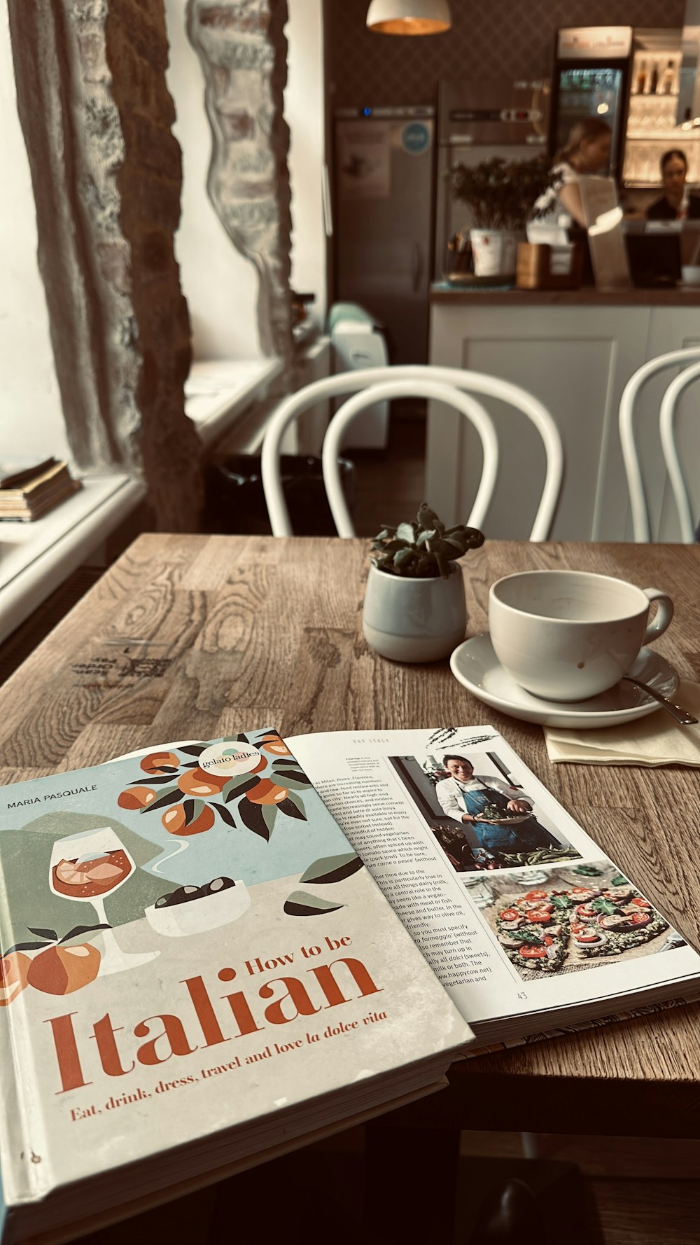 a table with a magazine and a cup on it