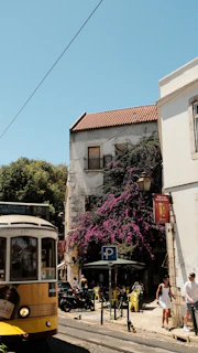 a yellow and white trolley on a city street