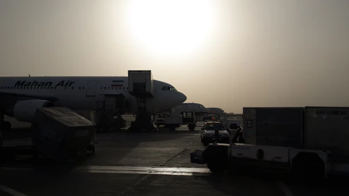 A large airplane being loaded with freight containers on a sunny tarmac.