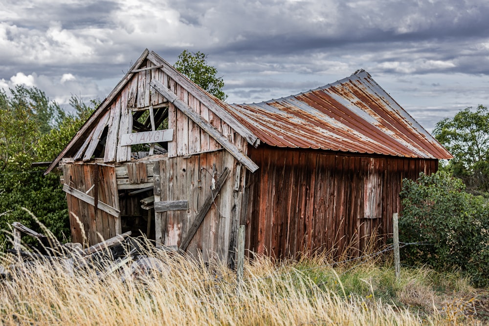 an old wooden barn with a rusty roof