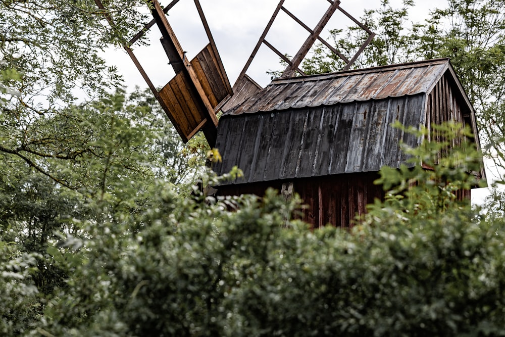 Eine alte hölzerne Windmühle, die mitten im Wald sitzt