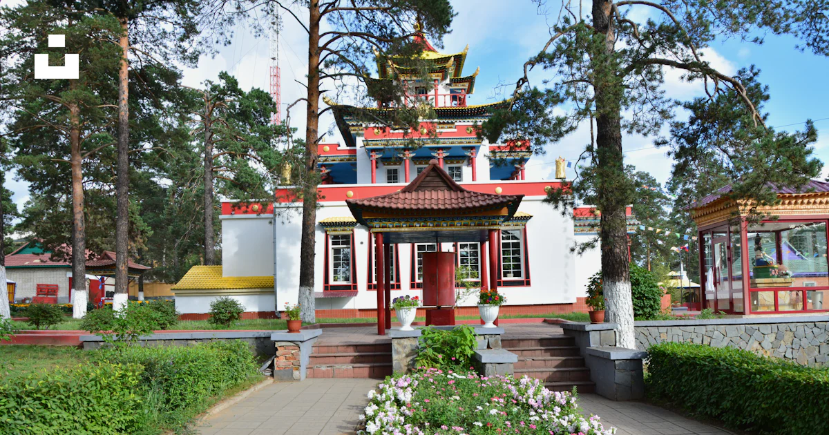 A red and white building surrounded by trees and flowers photo – Free ...