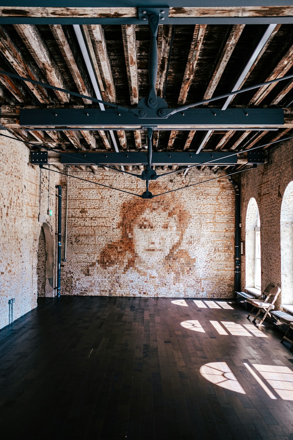 an empty room with a brick wall and exposed ceiling