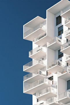 a tall white building with balconies and balconies