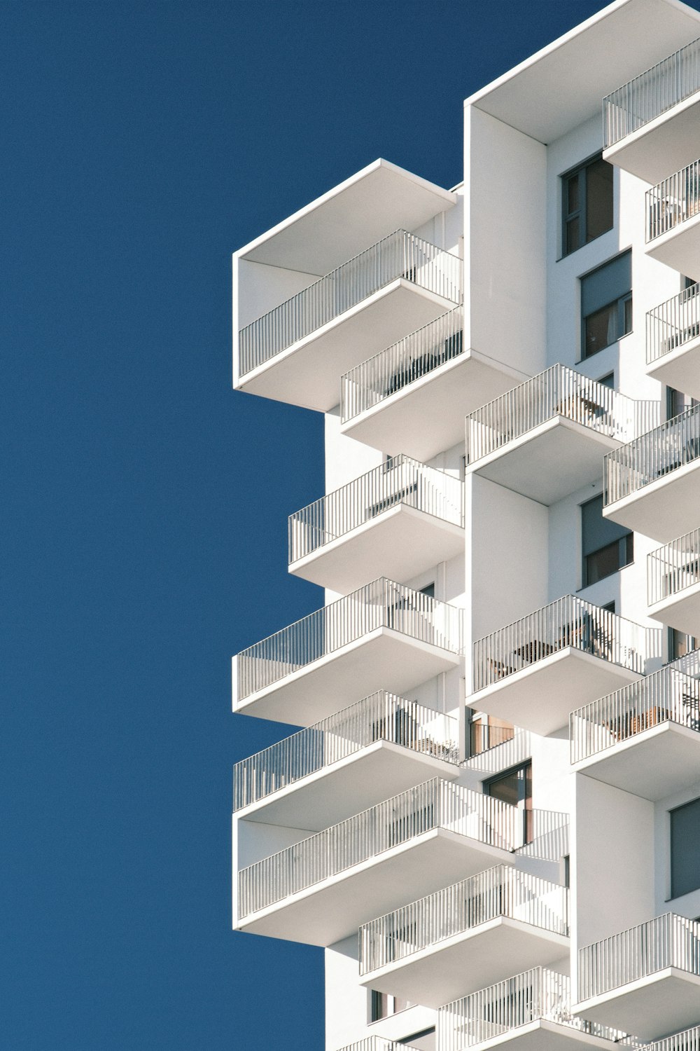 a tall white building with balconies and balconies