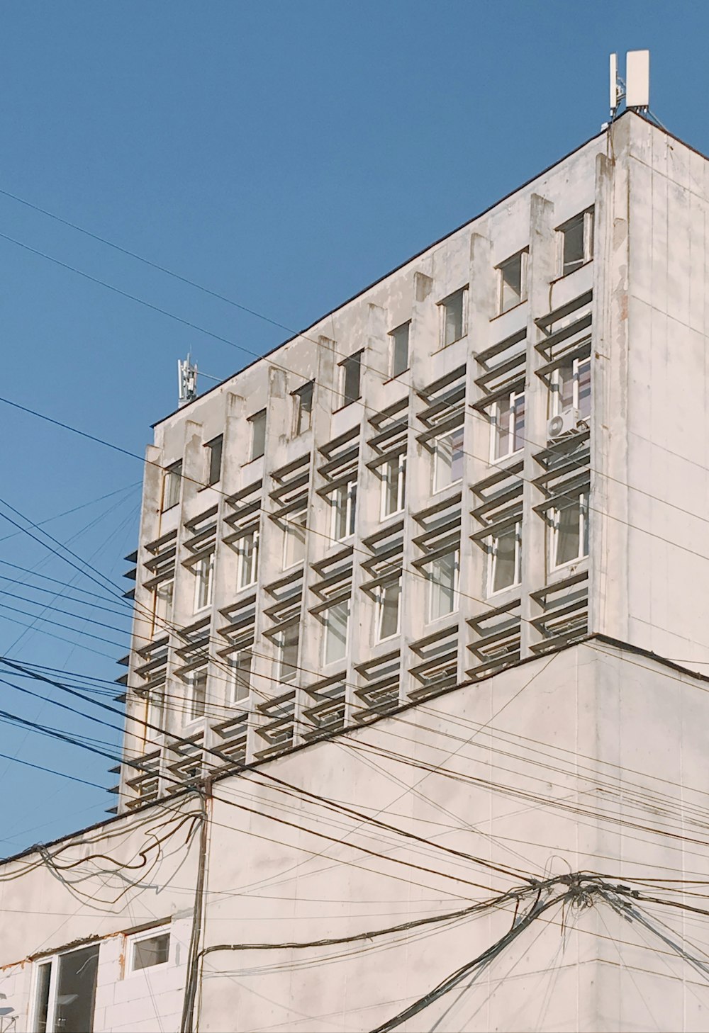 a tall building with lots of windows next to power lines