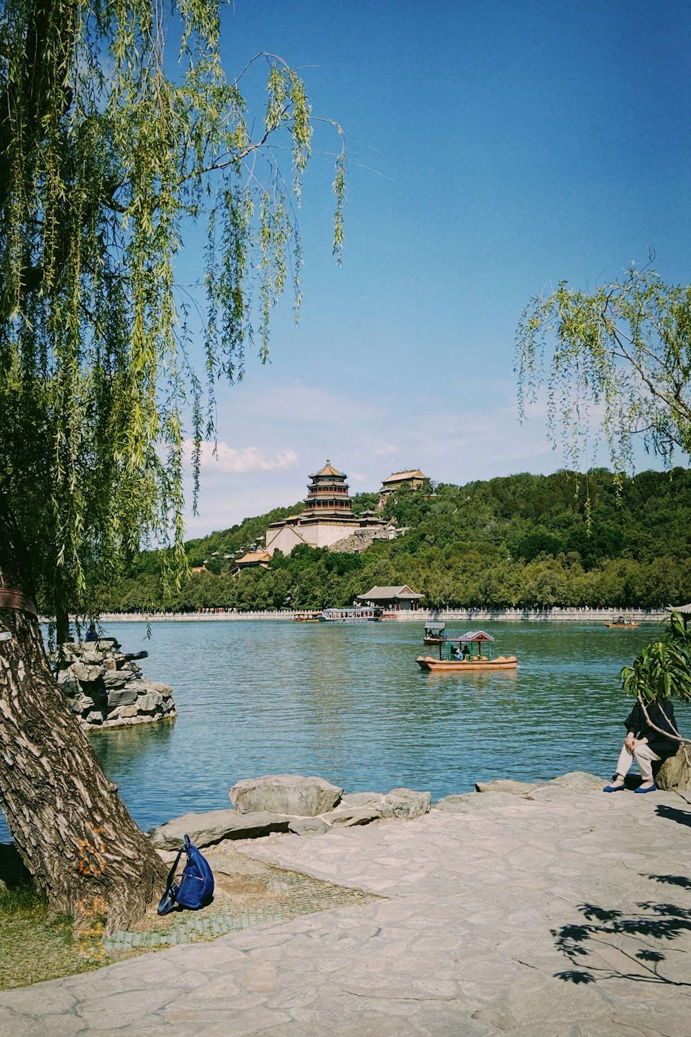 a person sitting on a rock near a body of water