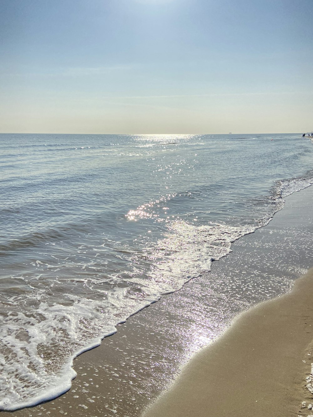 the sun is shining over the water at the beach