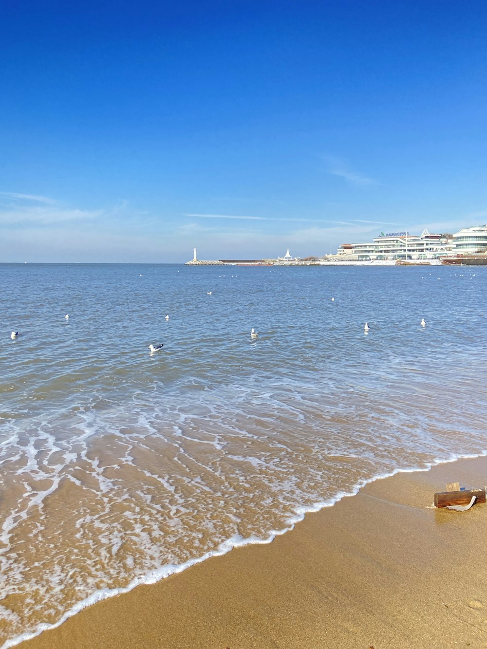 a sandy beach with waves coming in to shore