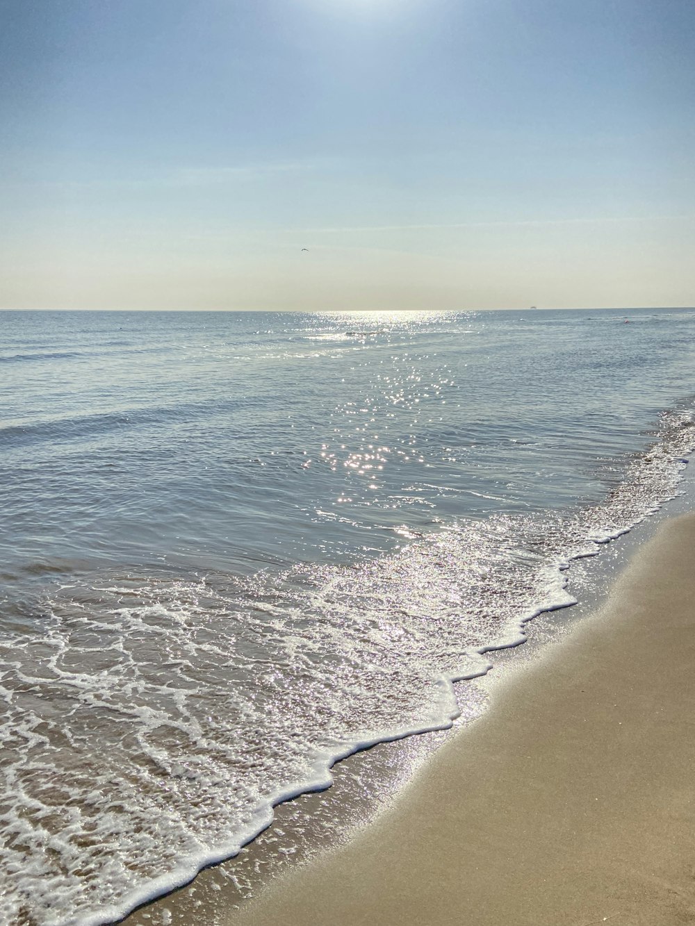 the sun is shining over the water at the beach